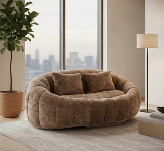Décoration de salon haut de gamme avec un canapé pouf panoramique beige sable, lampe sur pied design et grande baie vitrée offrant une vue panoramique sur la ville.