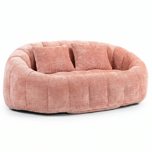 Grand canapé pouf arrondi de couleur vieux rose en tissu chenille texturé avec deux coussins carrés assortis sur fond blanc.