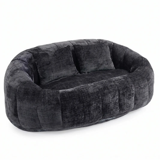 Canapé pouf panoramique arrondi gris anthracite en velours texturé avec deux coussins assortis, design moderne et minimaliste sur fond blanc.